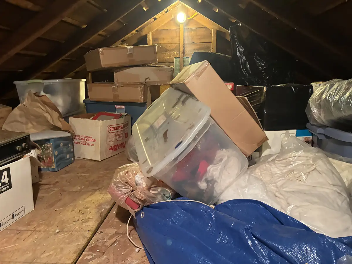 Attic packed with stored boxes and furniture before cleanout