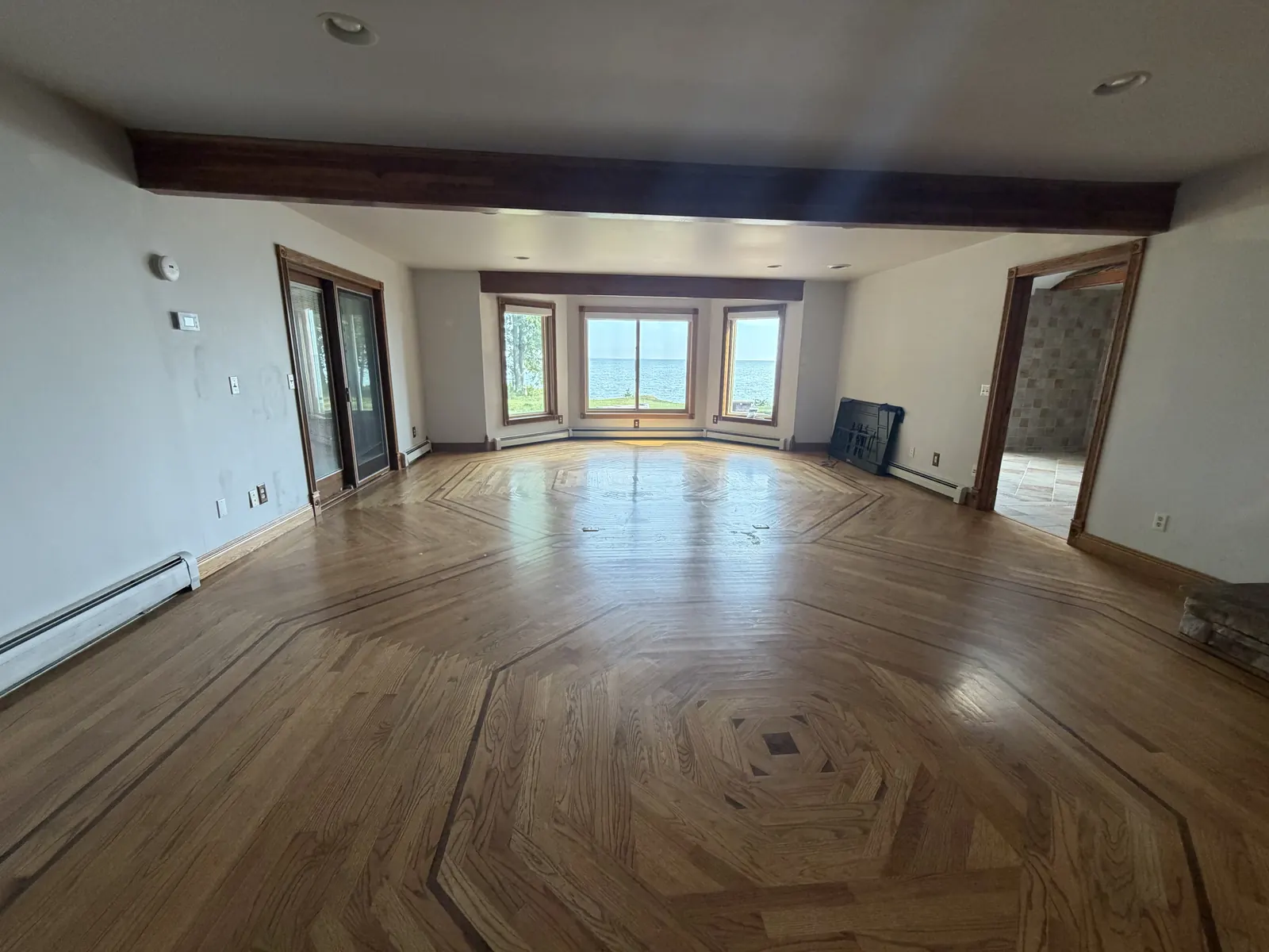 Emptied living room with inlaid hardwood floors after a full estate cleanout