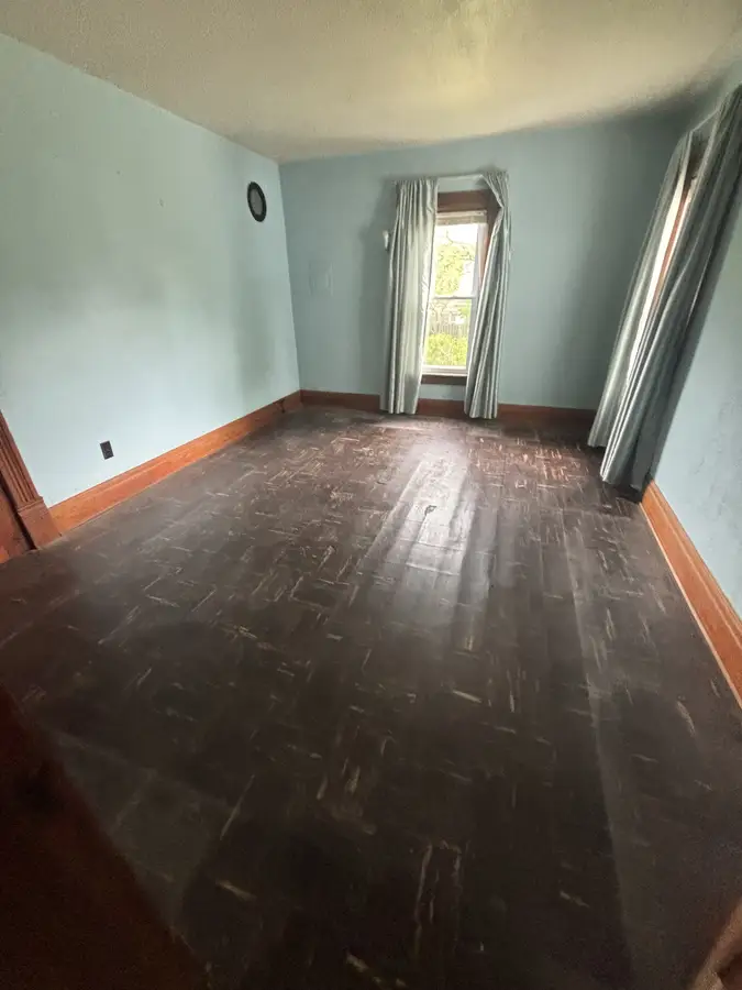 Bright cleared room with hardwood floors after a full cleanout
