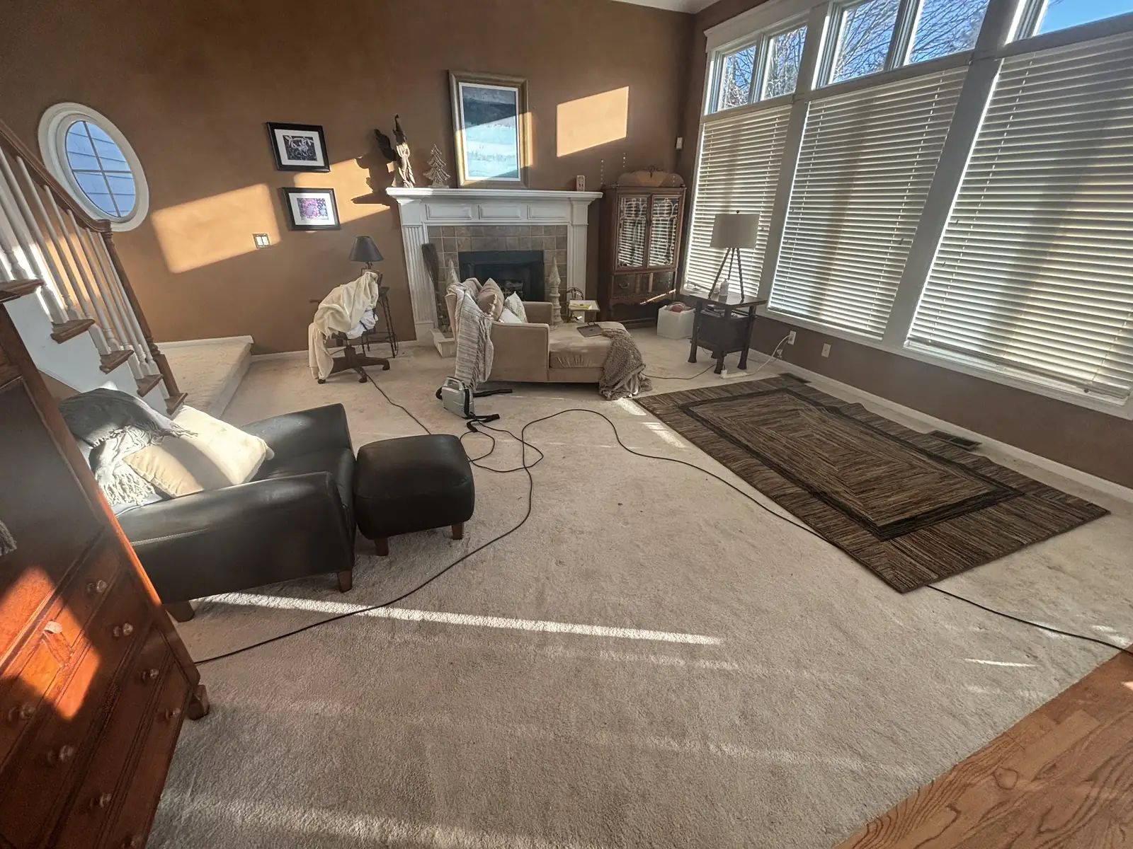 Sunlit living room with a fireplace and tall windows