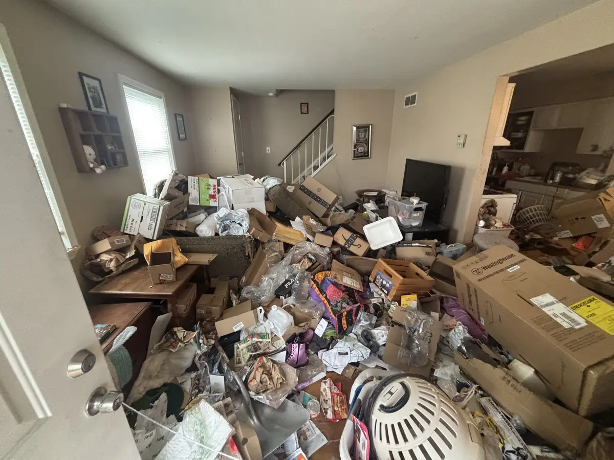 Living room filled with clutter before the cleanout