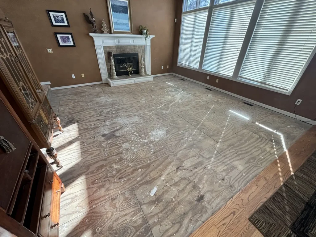 Empty living room with a fireplace and tall windows after the contents were cleared