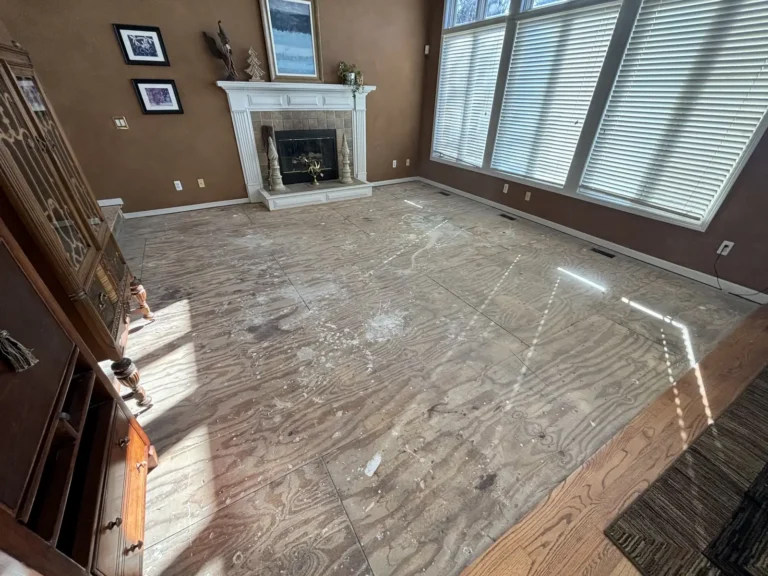 Empty living room with a fireplace and tall windows after the contents were cleared